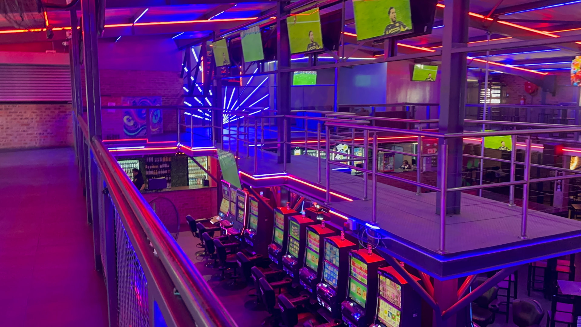 Neon-lit double-volume main hall balcony above the machine floor at Cheeky Tiger Midrand